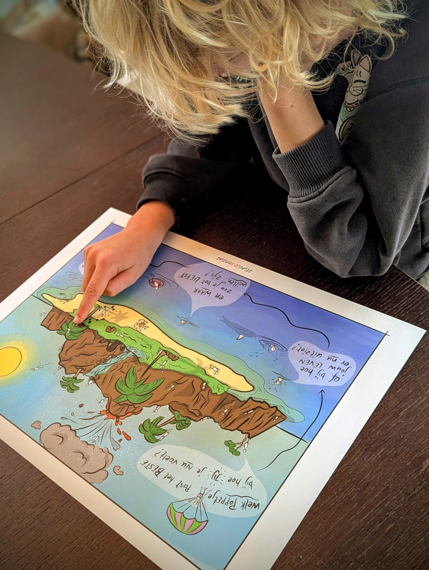 Leerling wijst een poppetje aan op de praatplaat 'het eiland van je leven', dat staat voor hoe hij zich op dit moment voelt.